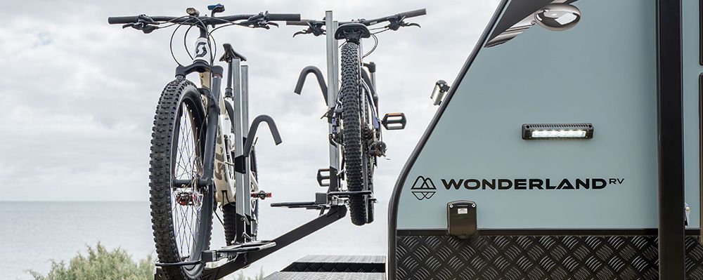 Two mountain bikes on a rear bike rack fitted to a caravan by the sea