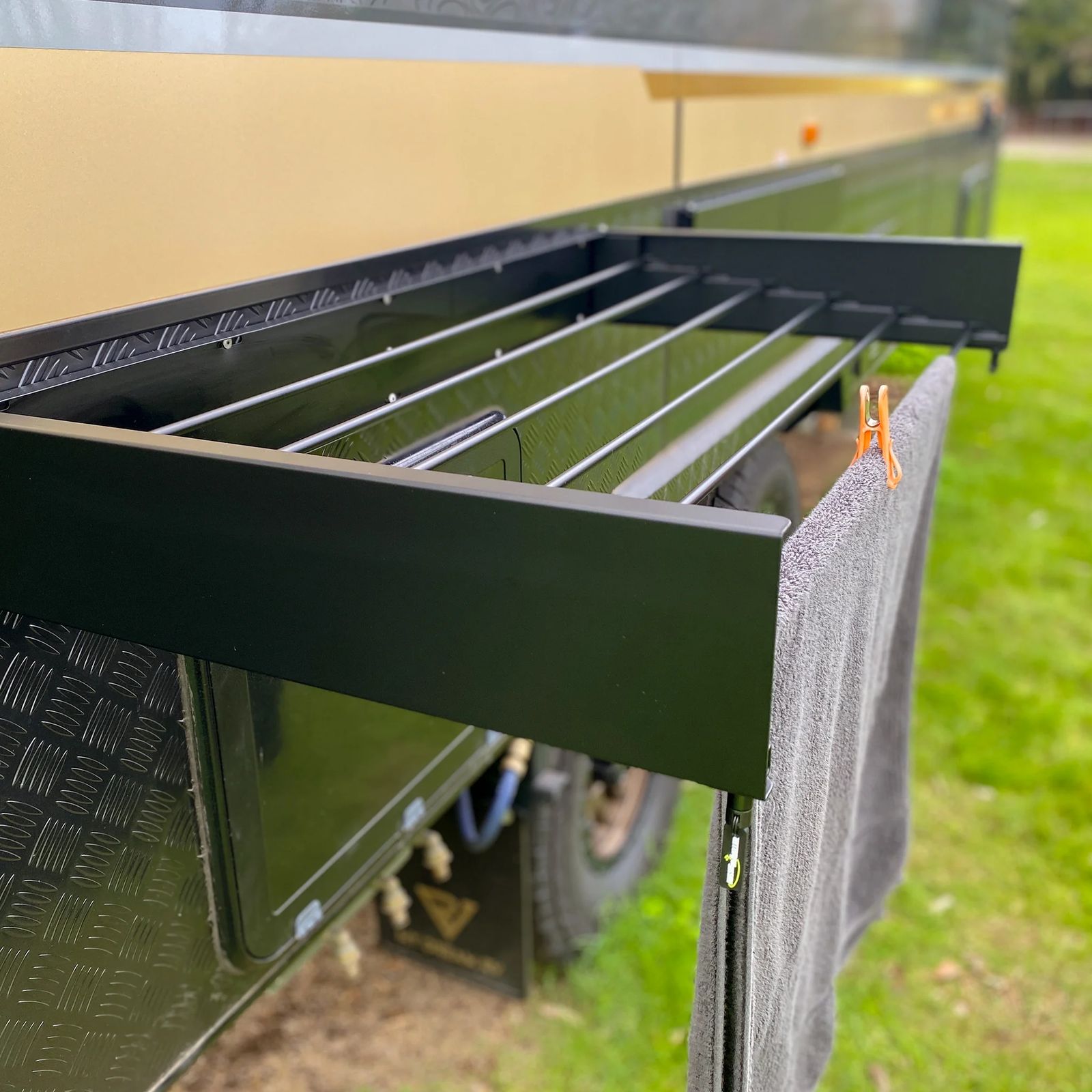 A fold-out clothesline rack fitted to the side of a caravan