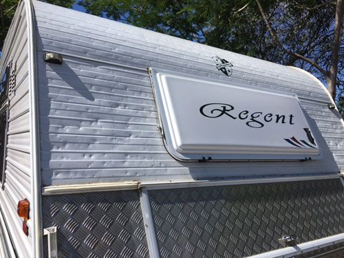 Hail dents across the aluminium cladding of a caravan front