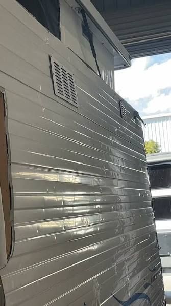 Hail-dented caravan wall panel in the workshop