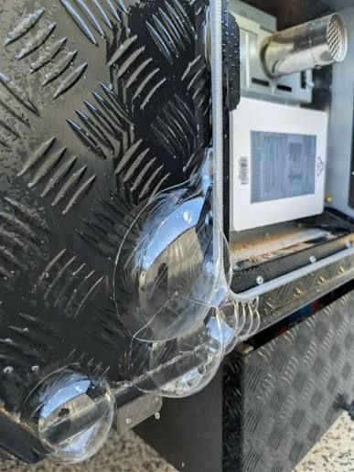 Air bubbles forming at a caravan corner seam during a pressure leak test