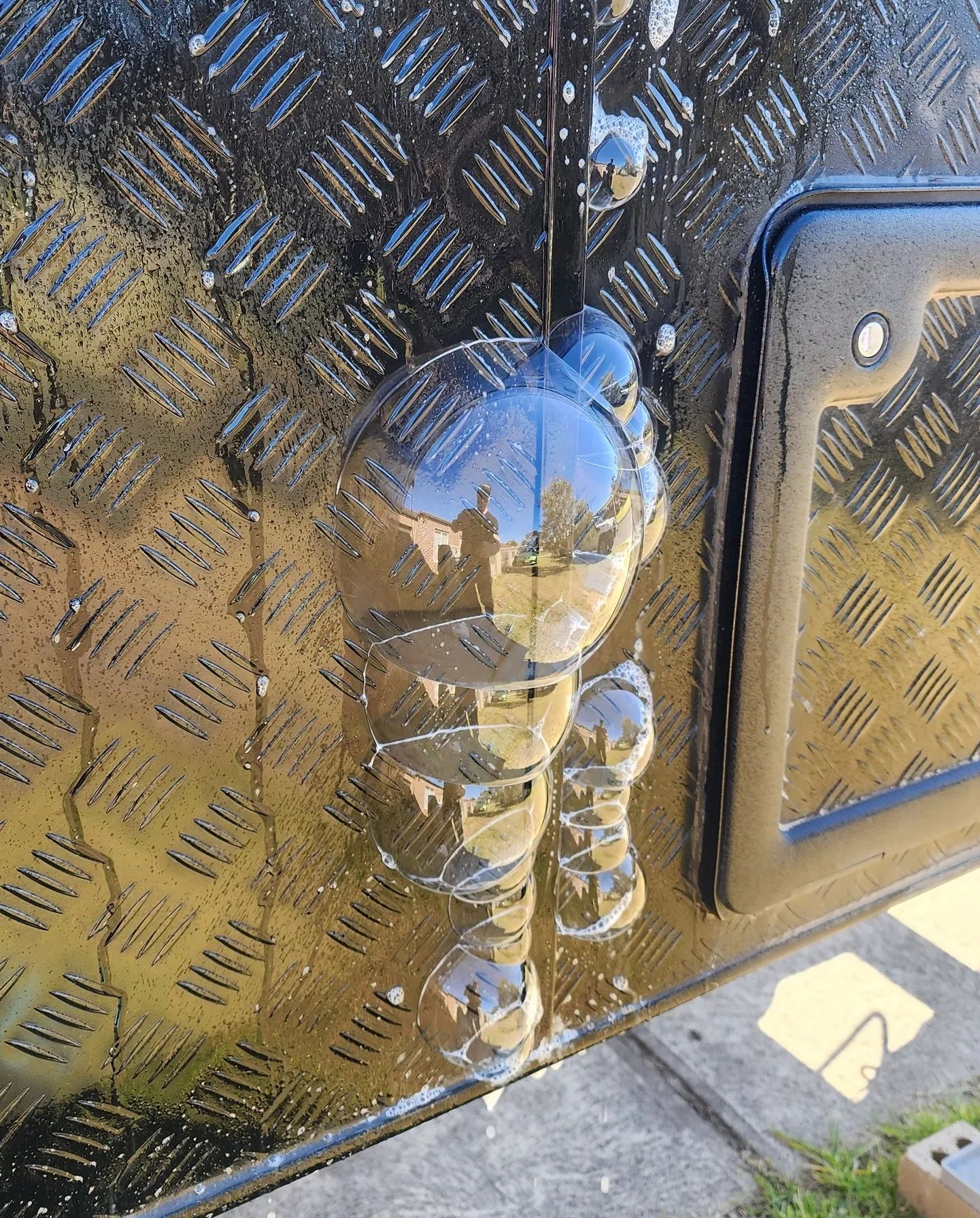 A cluster of bubbles revealing a leak at a caravan checkerplate join